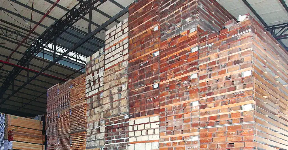 NORMAN🄬の工場内で乾燥保管されているウエスタンレッドシダ。大量のの板材が積み重なっている。