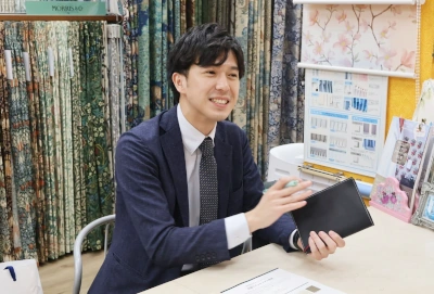 カーテン専門店でサンプル帳を開きながら商談している様子