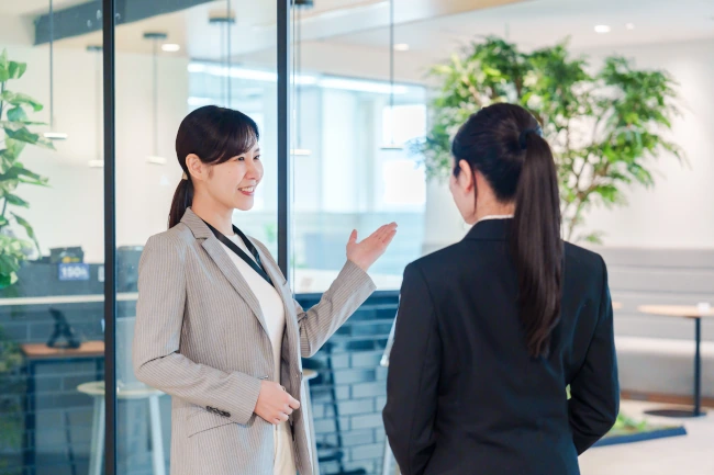 リクルートスーツの女性に職場の案内をする女性
