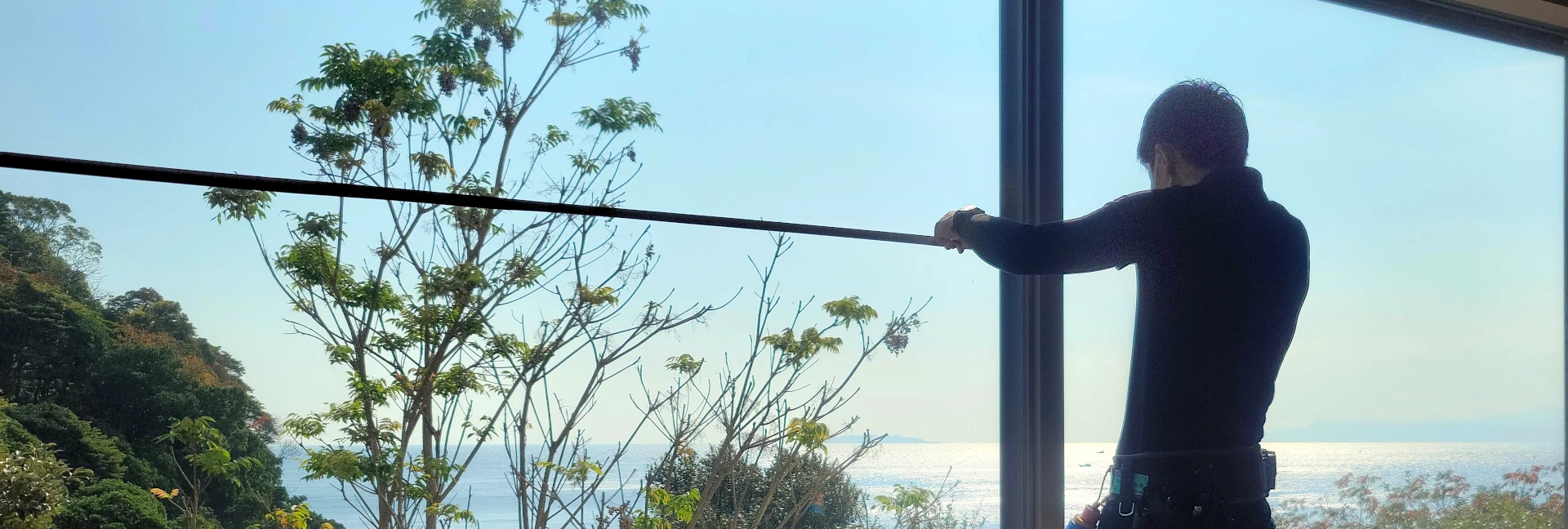 ノーマンジャパン採用ページ セールスエンジニア部（採寸施工担当）スタッフ募集 キービジュアル（PC用）　男性作業員が窓のサイズを図っている様子