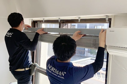 2名のノーマンジャパンの男性スタッフが窓に桐ウッドブラインドを取り付けている様子