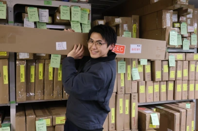 ノーマンジャパンのスタッフが自社倉庫で段ボールを運んでいる様子