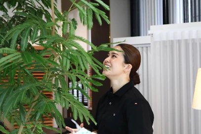 ショールームで観葉植物の世話をする女性