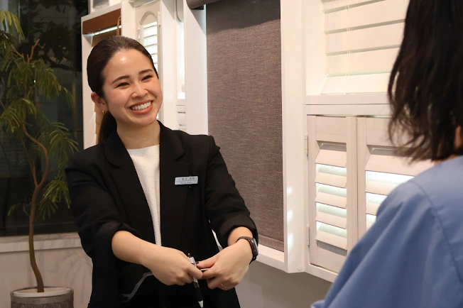 ショールームで女性のお客様に製品説明をするスーツ姿の女性スタッフ