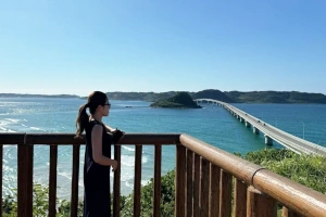 女性が展望台に立ち、海を見渡している風景の画像
