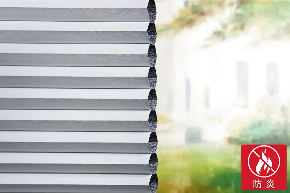 遮光防炎生地のクローズアップ写真と、右下に防炎マークがある