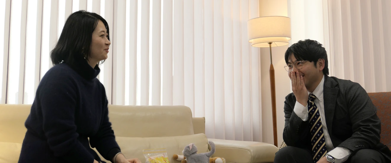 スマートドレープシェードの前でソファに座りながら話をするノーマンジャパンスタッフ2名