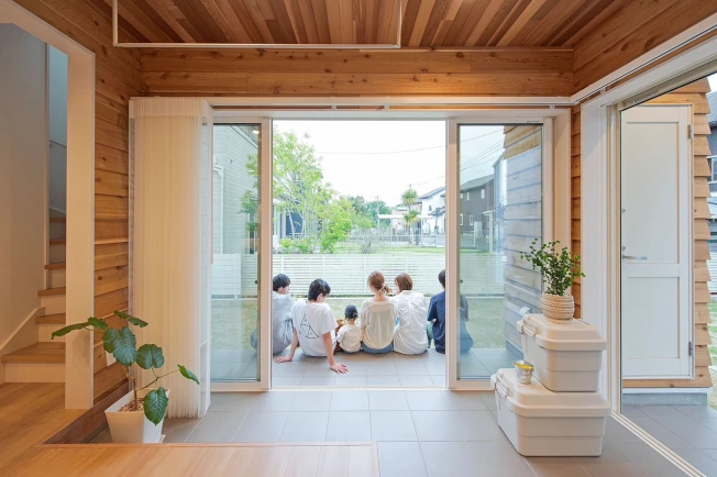 スマートドレープシェードを全開にして、眺望が開けてい様子。デッキに友人家族が座っている。