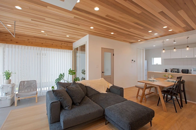 リビングダイニングとキッチンが収められた広角写真。板張り天井が印象的。